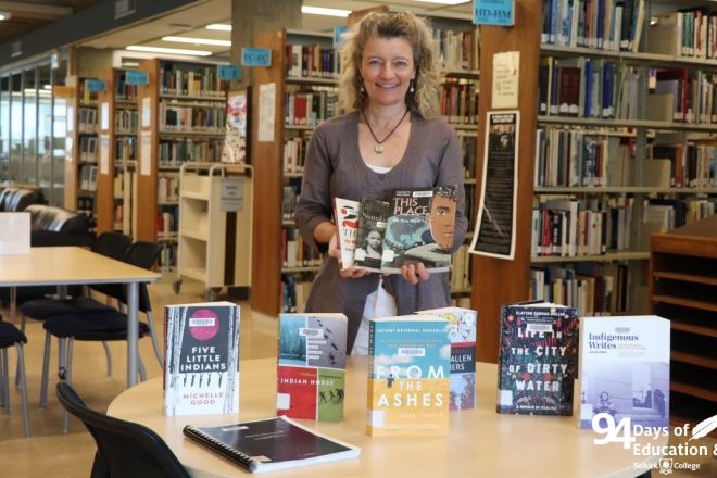 An image of Jennie Barron in the library surrounded by books