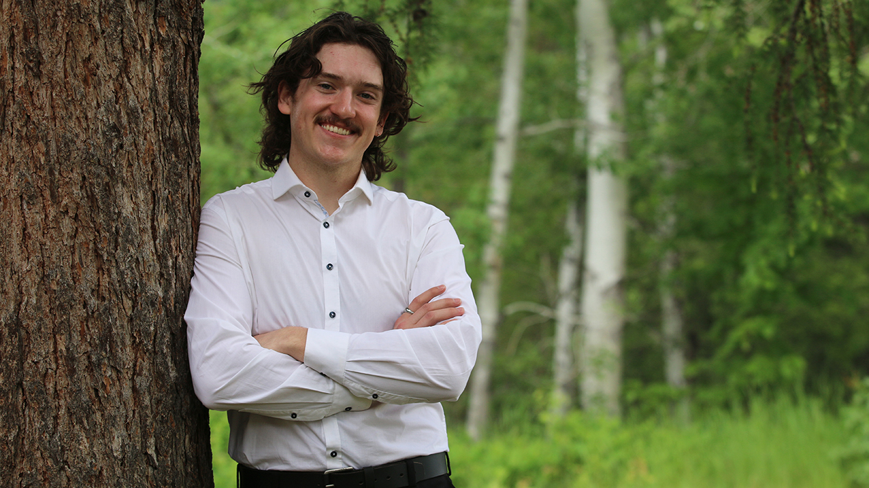 Rural Pre Medicine Program graduate Ben Koenig stands by a tree