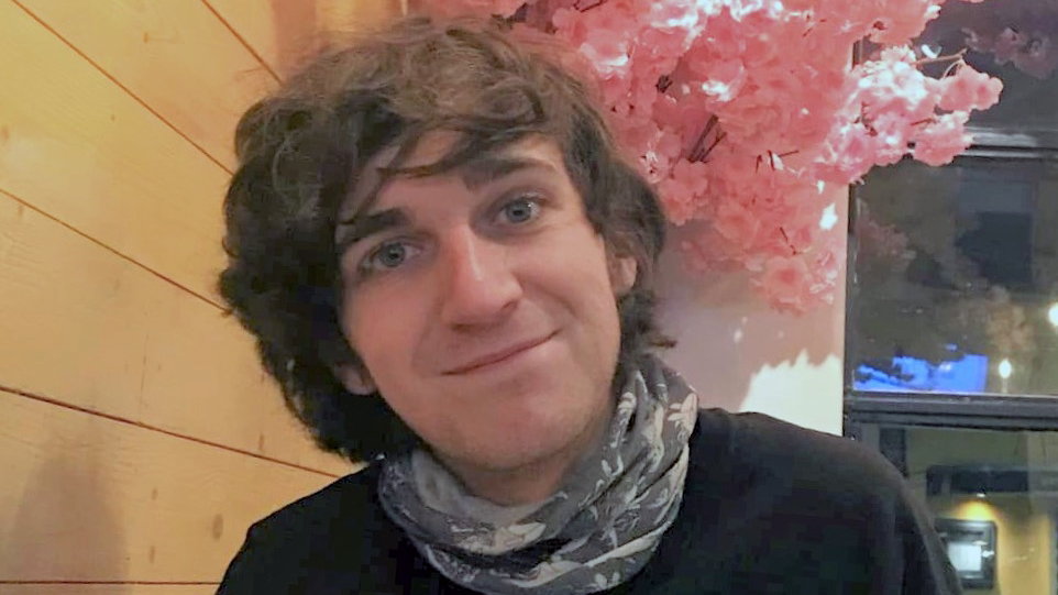 Aubrey smiles with pink flowers in the background