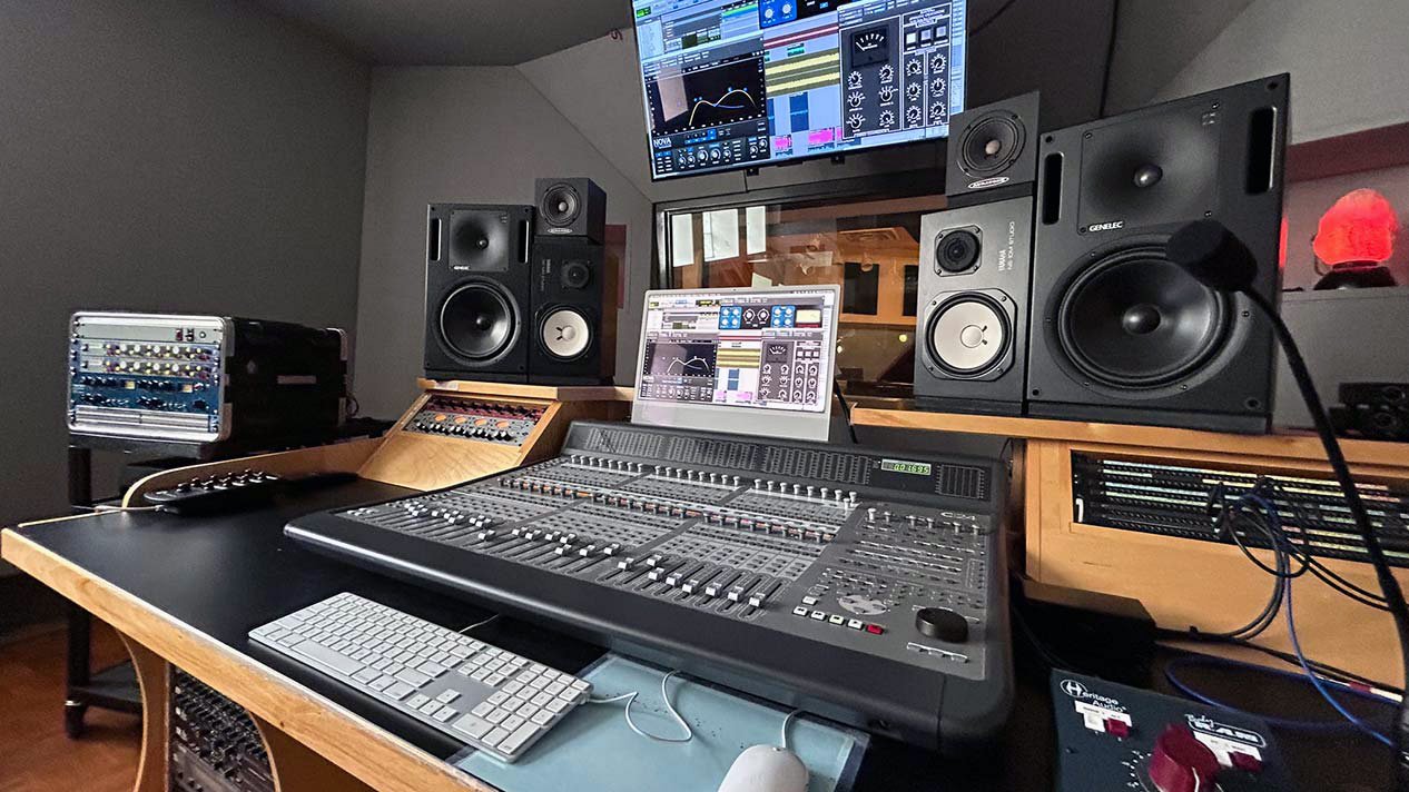 A recording studio with gear, computers and speakers