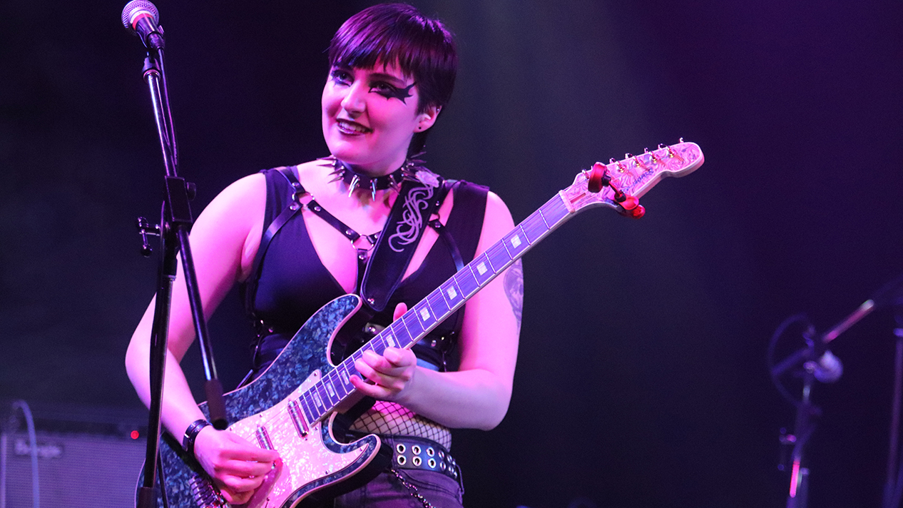 Class of 2024 co-valedictorian Jay Porteous playing guitar on stage