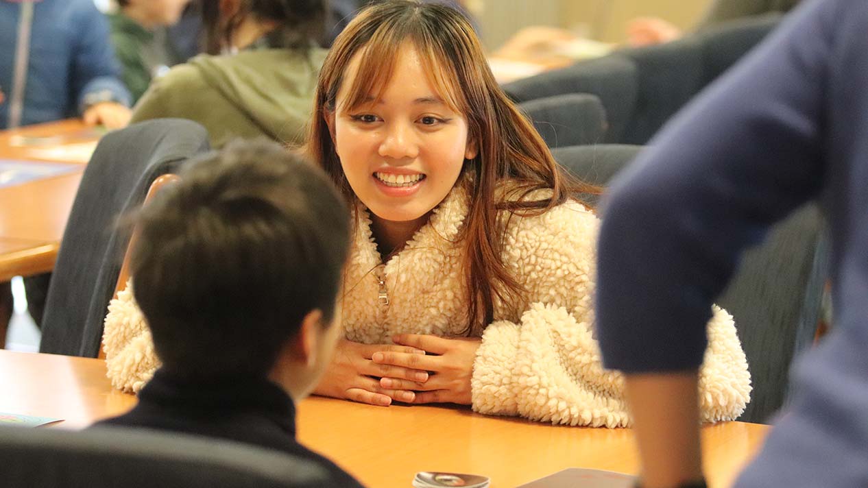 Female Selkirk College student chats with Hume Elementary students at the Monster Party