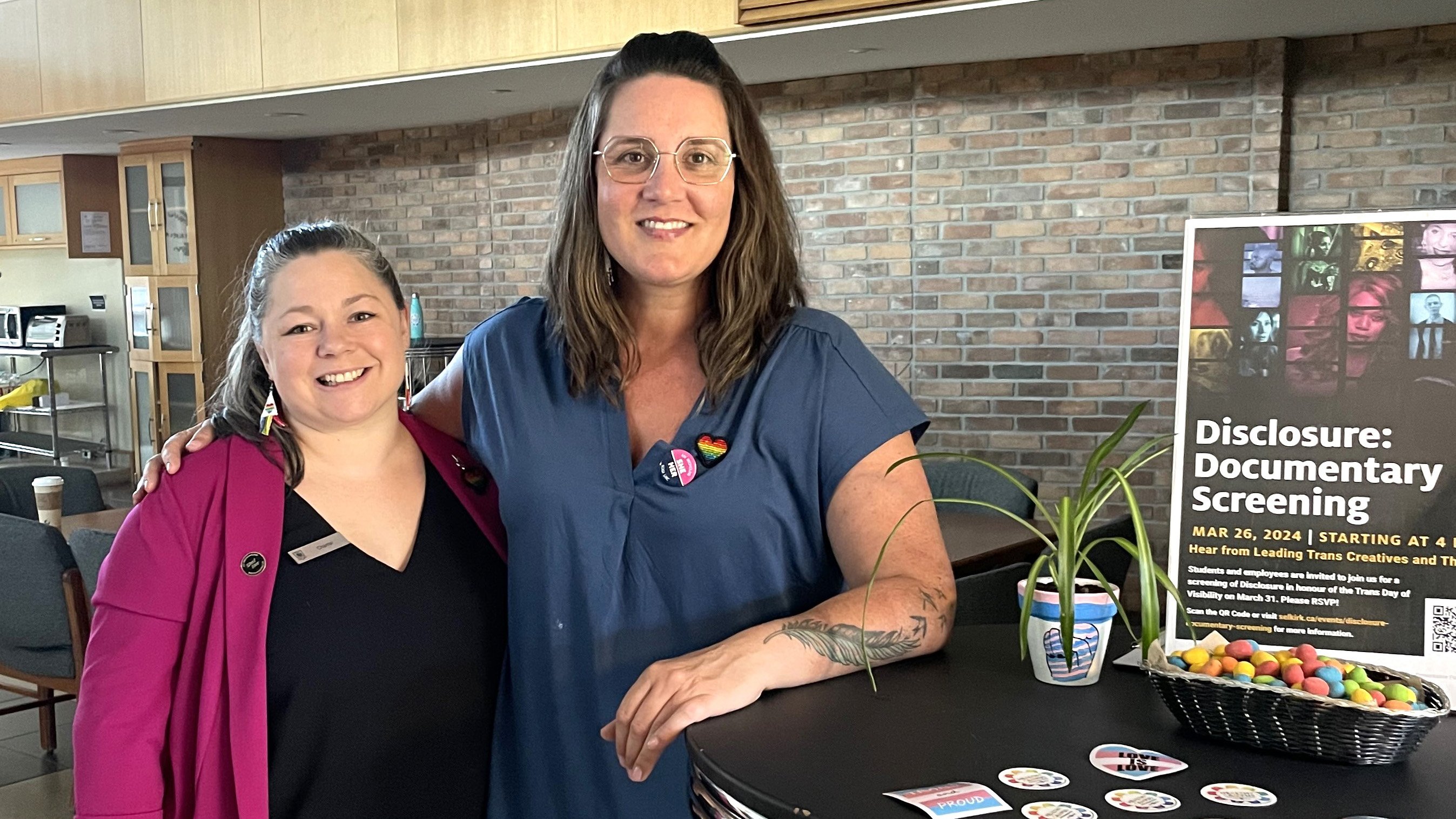 Two people stand smiling