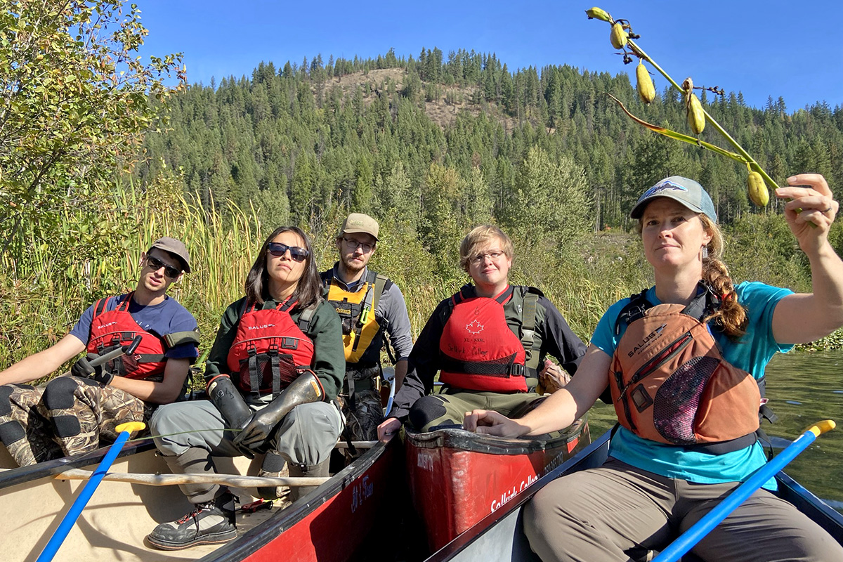 Students learning about plants on the water in canoes