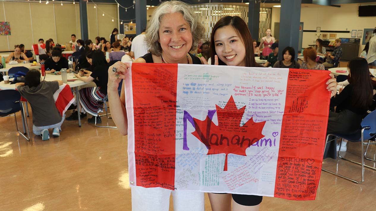 International student and teacher hold Canadian flag