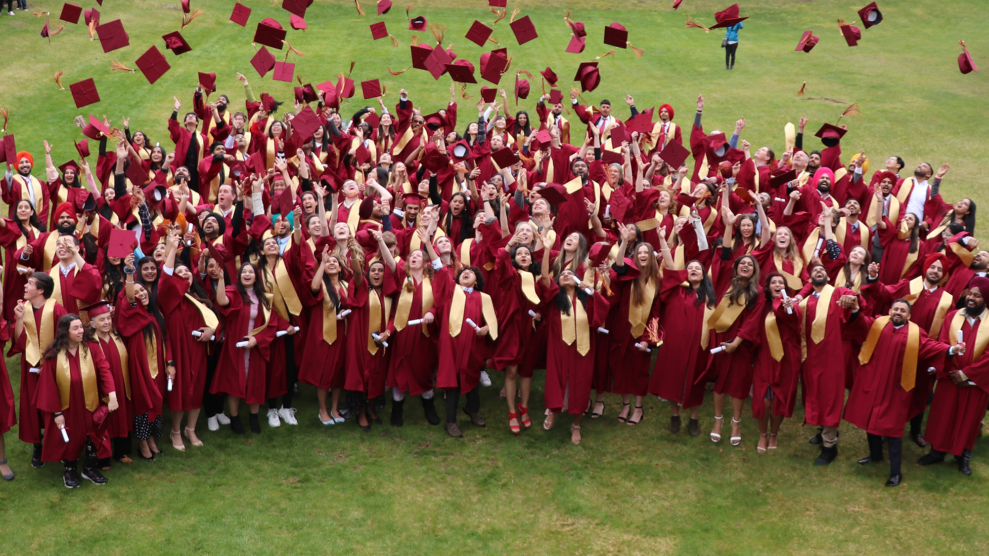 Students at convocation throwing their hats into the air