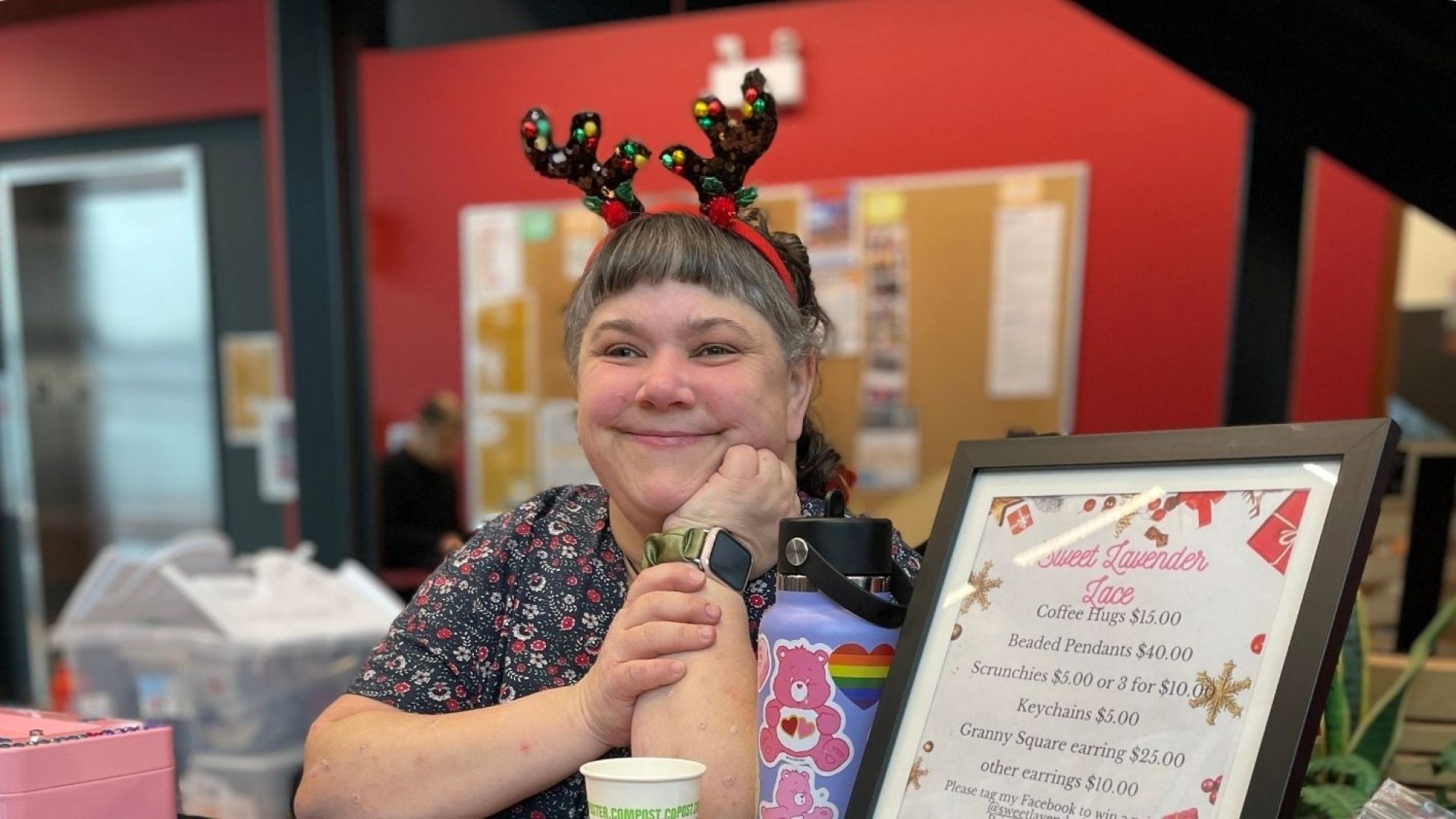 Student smiling wearing antlers selling crafts at winter market