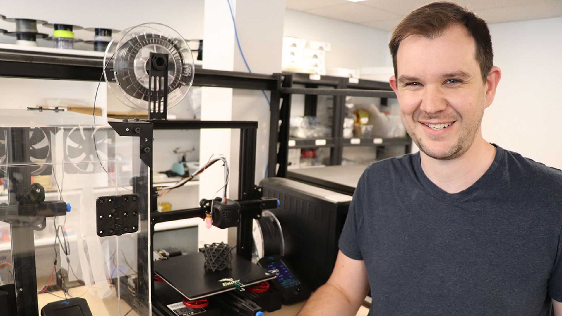 Student smiling beside 3D Printer