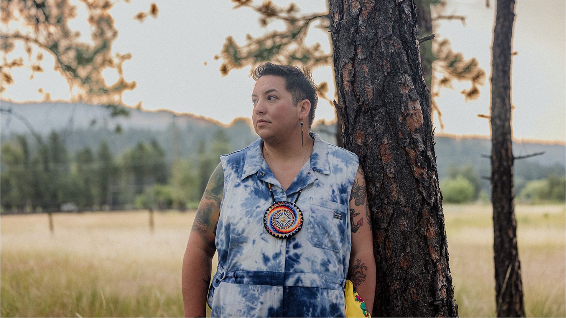 Smokii stands outside next to a tree