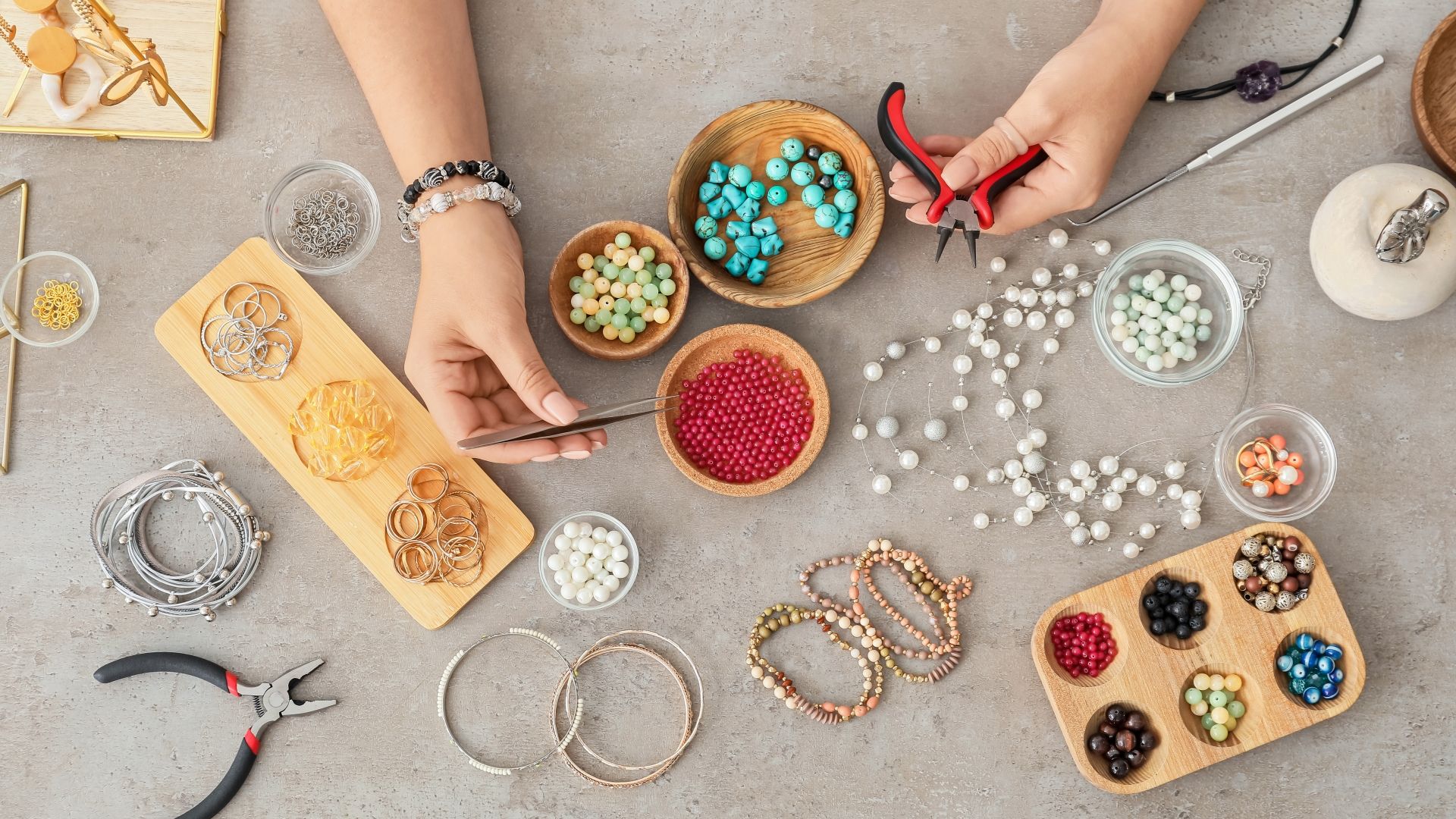 A woman's hands begin making a bracelet with crafting materials
