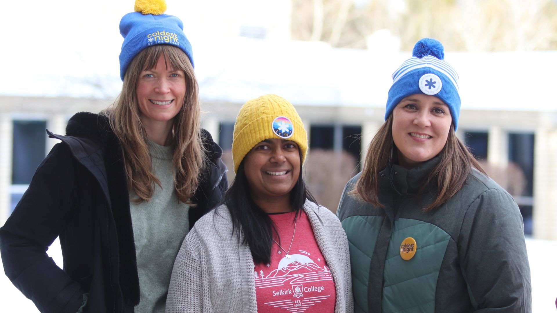 Three employees stand together wearing Coldest Night of the Year toques