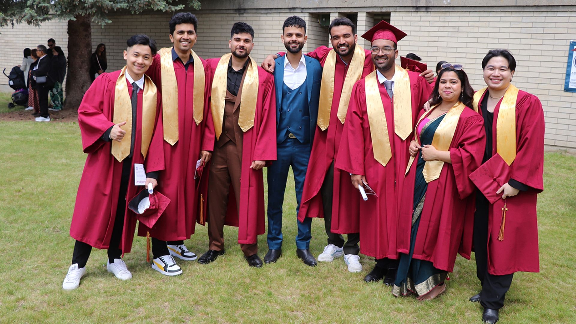 Group of graduates gather on lawn for photo