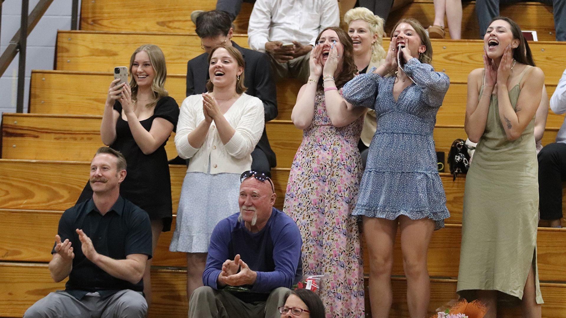 Friends cheer on grads in the gym