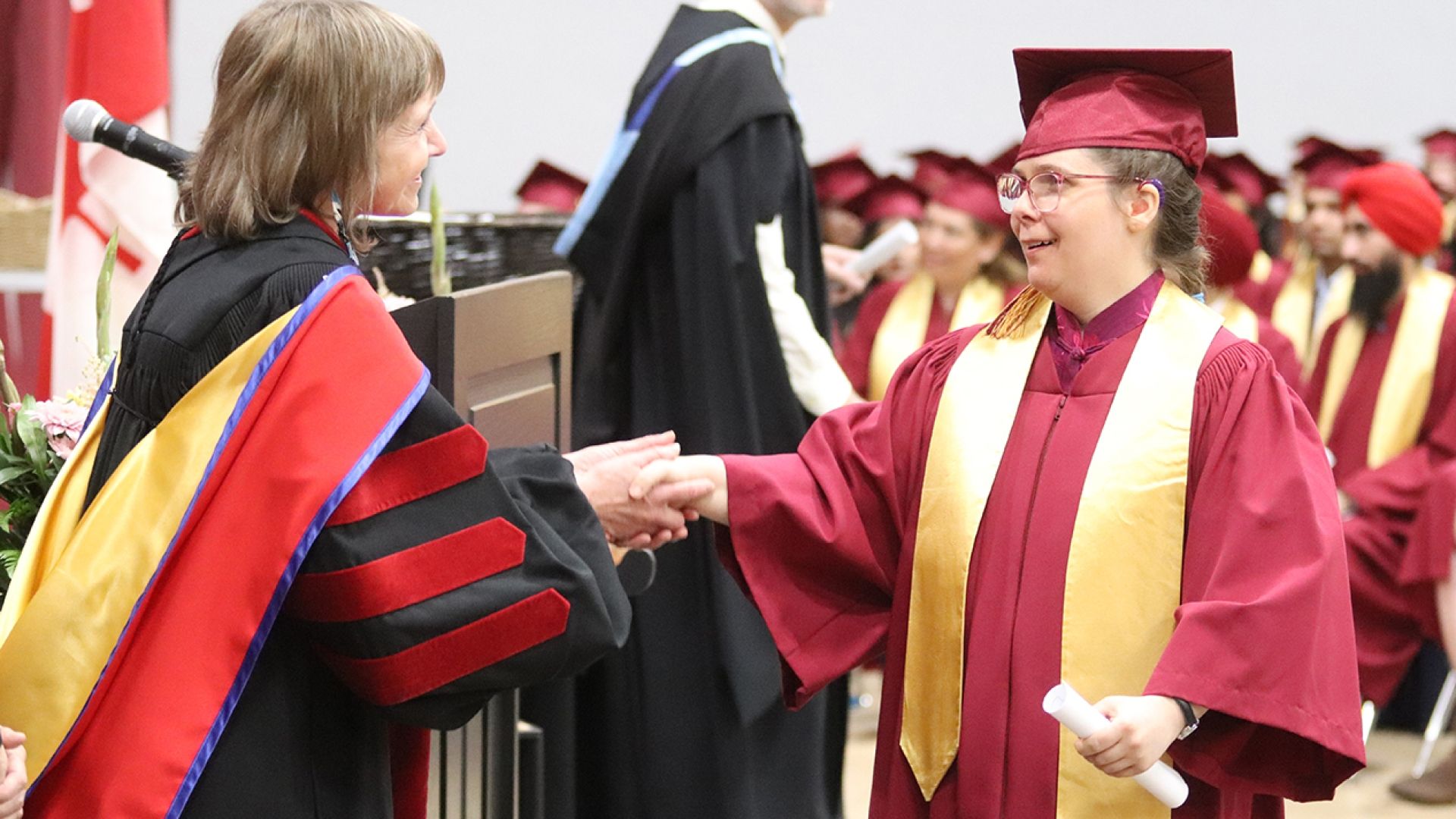 Selkirk College graduate from SOAR Program shakes hands with president