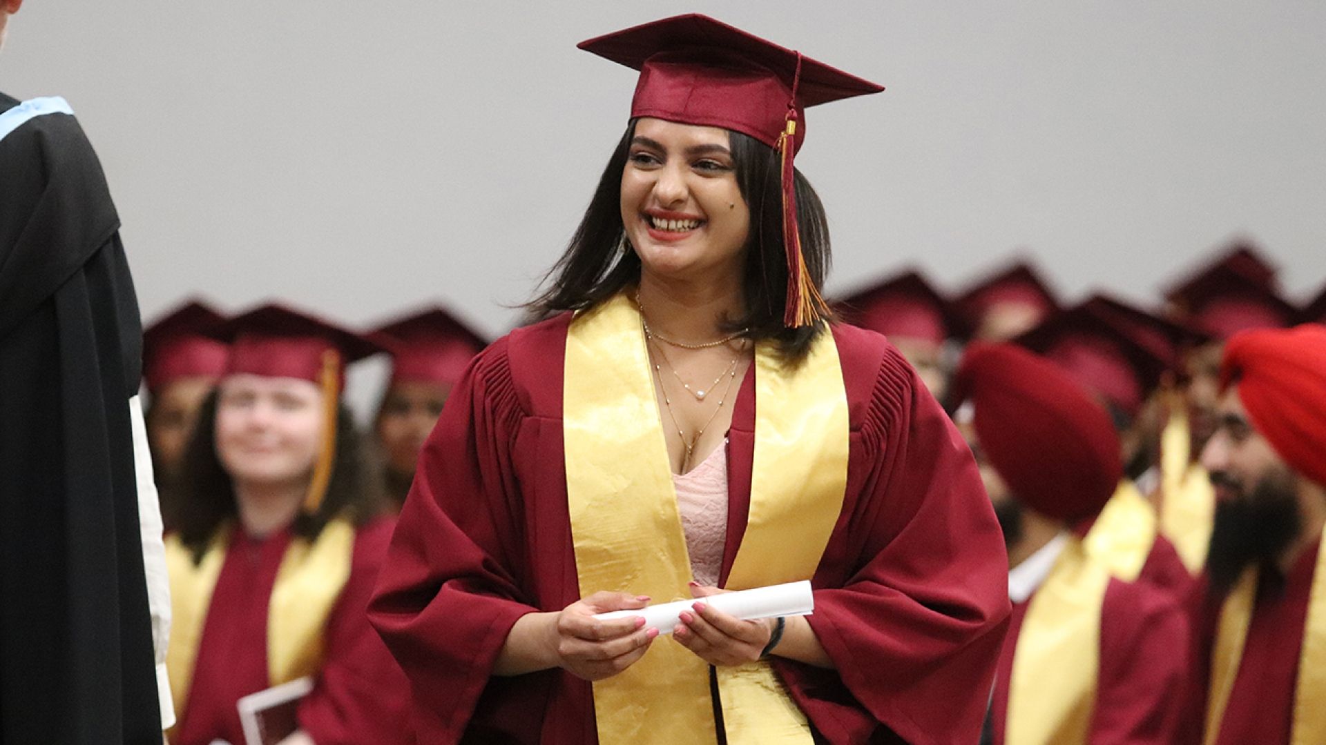 Selkirk College graduate with walking across stage with diploma
