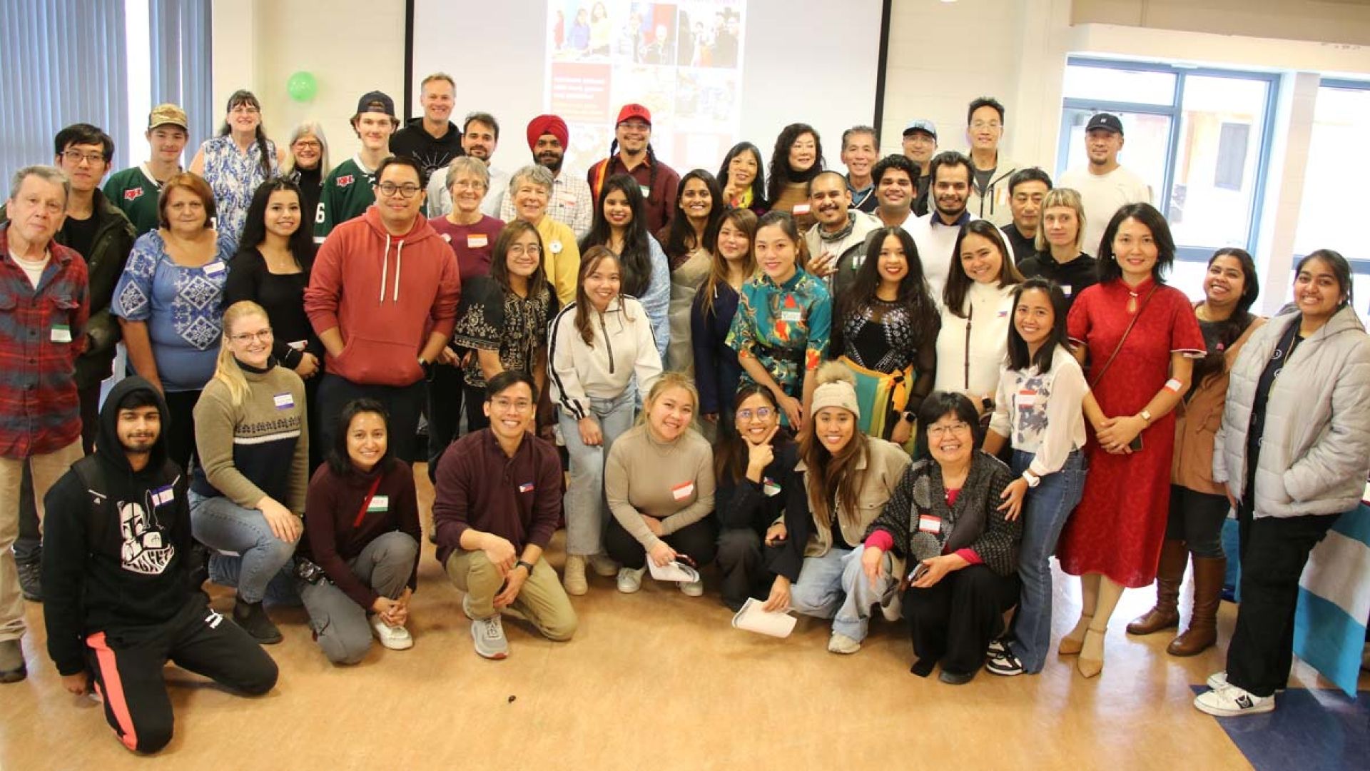 A group of students and employees gather and smile