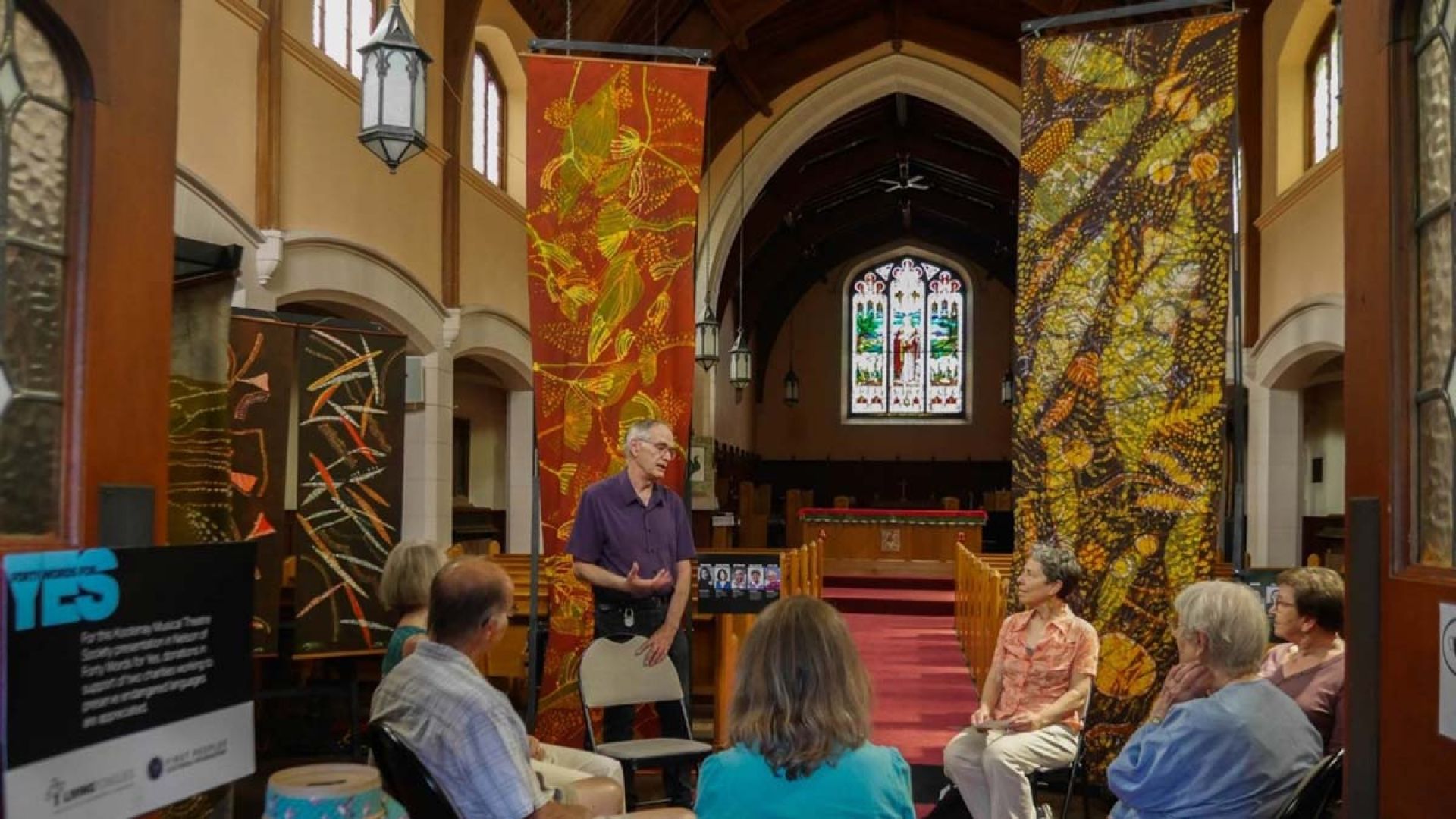 A group of singers sit talking in a church
