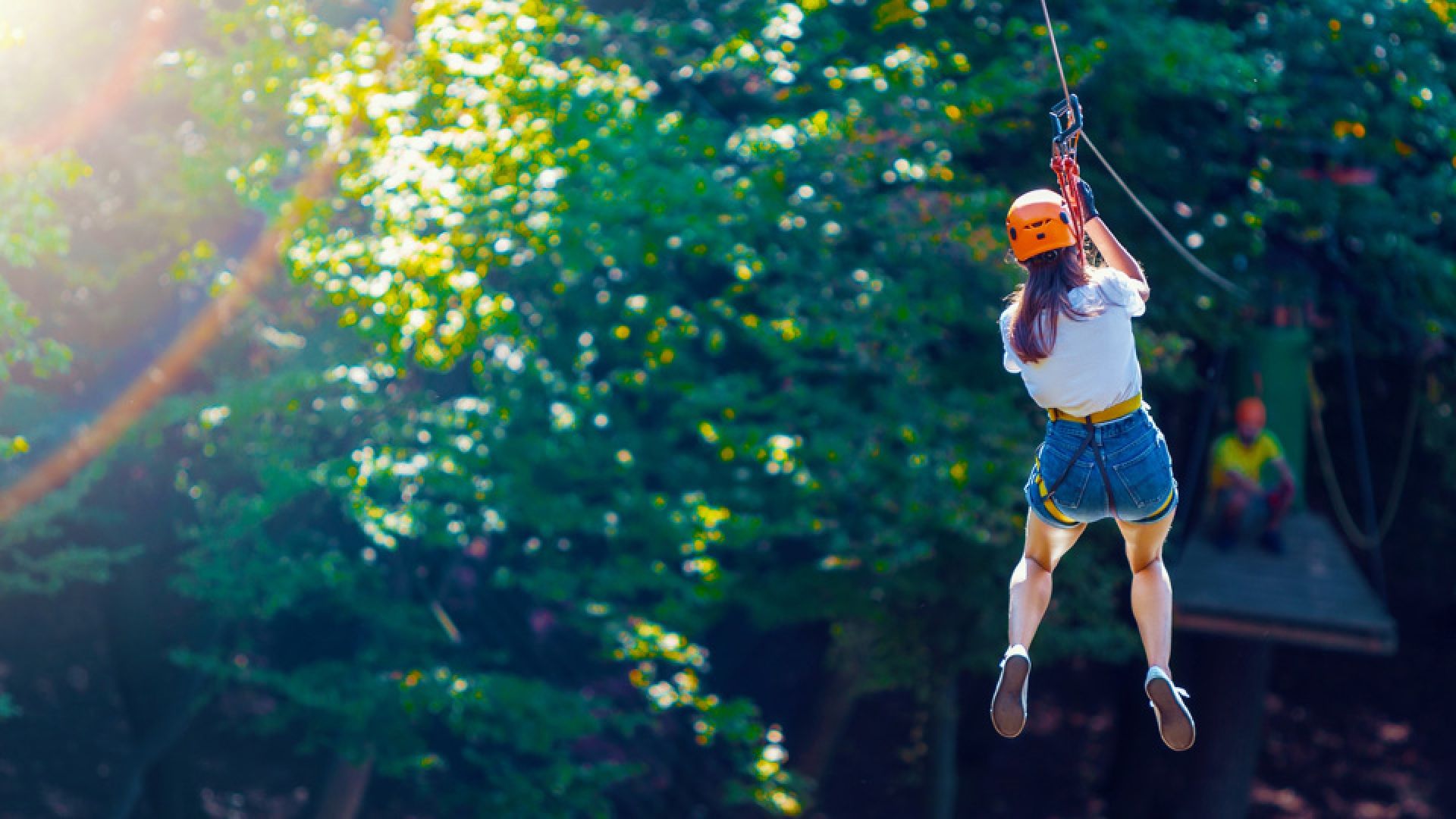A person ziplines through trees