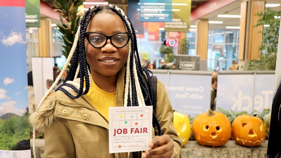 Student holding a job fair card at an event