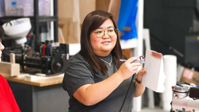 A student holds an airbrush