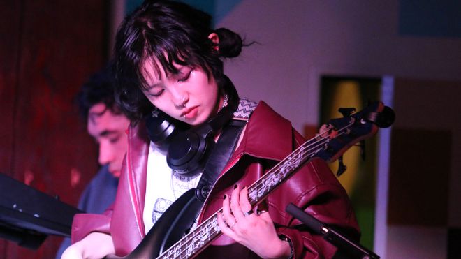 A student plays guitar on stage