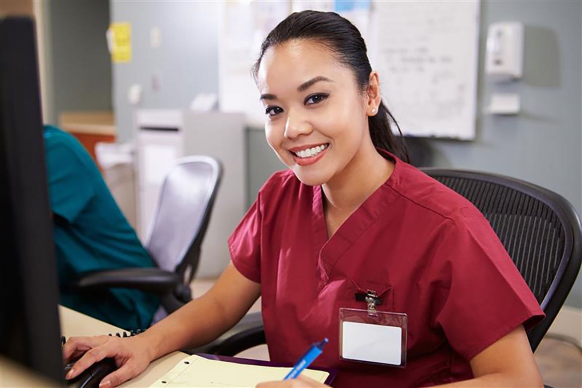 A health care worker sits at a desk