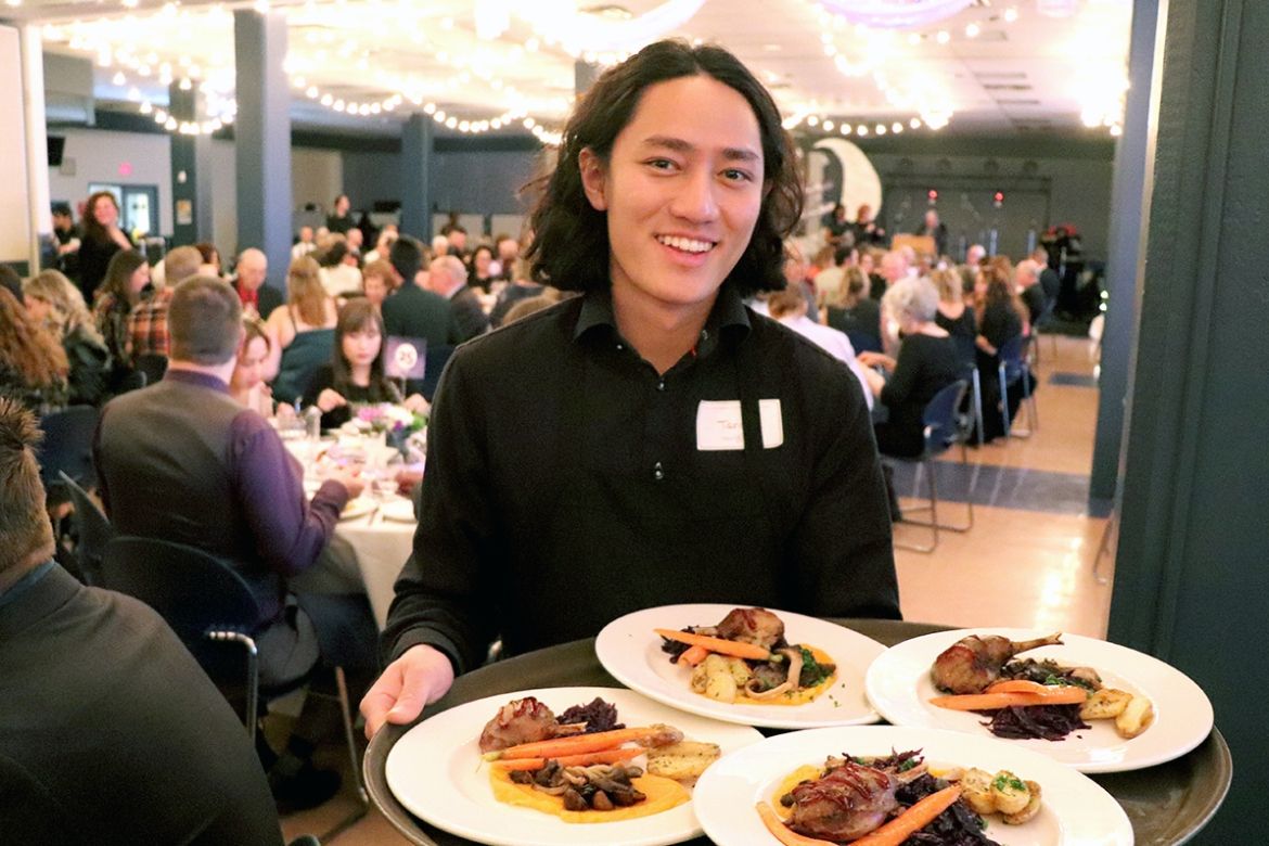 A server holds a try of plates