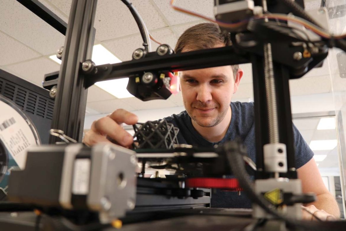 A student works with a 3D printer