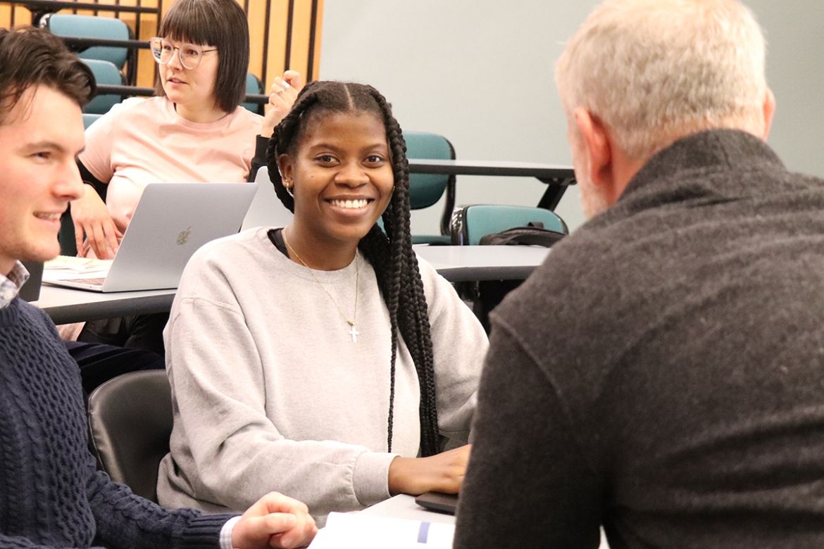 Student smiling while working with instructor
