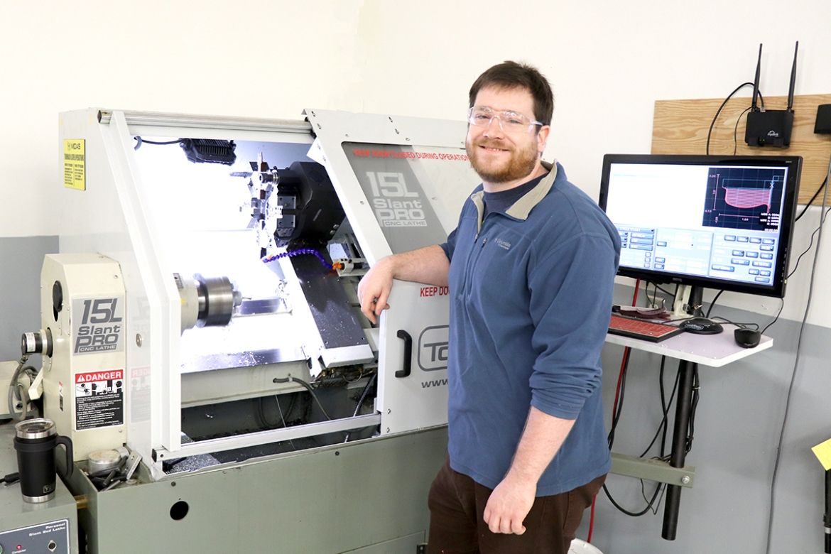Man working with a machine at the Selkirk Technology Access Centre