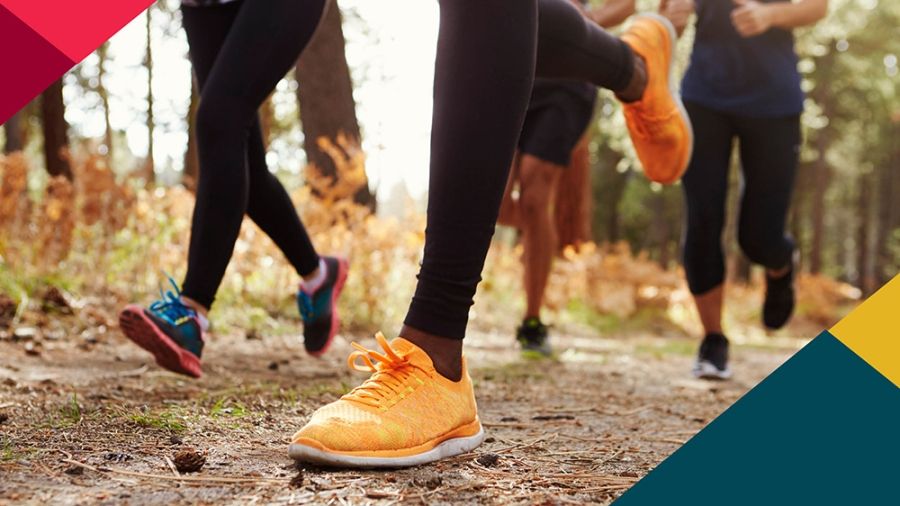 Feet in running shoes on a forest trail