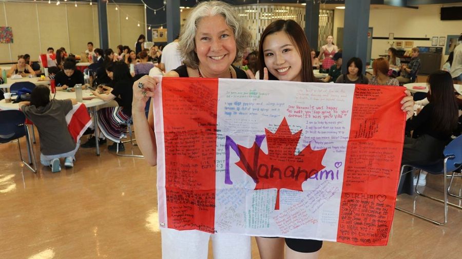 International student and teacher hold Canadian flag