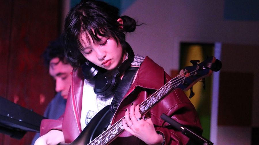A student plays guitar on stage