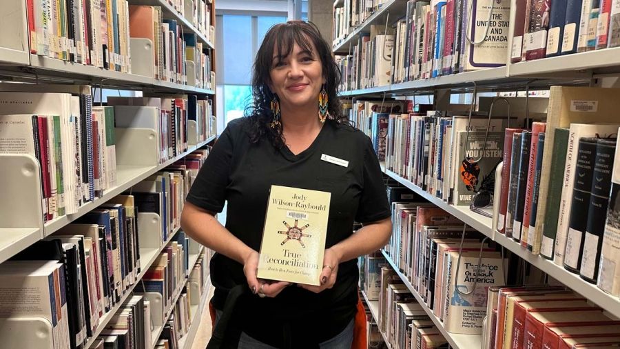 Sarah Lechthaler holds a copy of the book Truth and Reconciliation