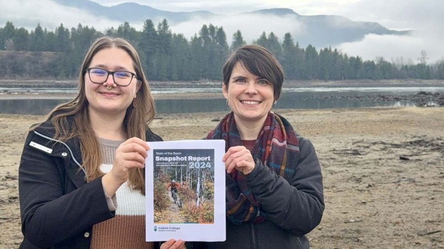 Selkirk Innovates researchers stand outside holding a copy of the Snapshot Report