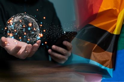 A photo of a hand holding a globe merged with a rainbow flag