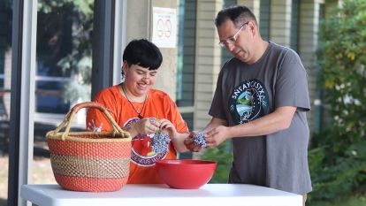 Two people pick and clean berries