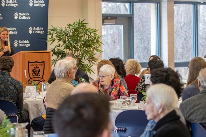 A group of donors sit and listen to a speaker