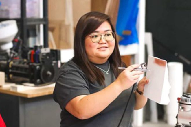 A student holds an airbrush