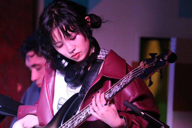 A student plays guitar on stage