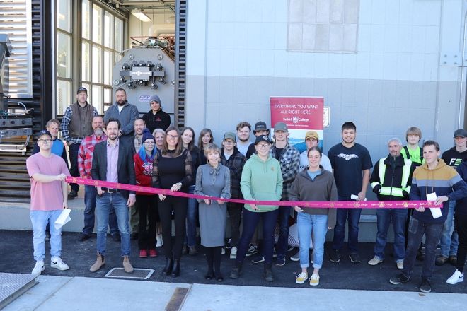 Selkirk College students from the Plant Operator Program join members of the leadership team and contractors in cutting the ribbon on a new biomass boiler located at the Silver King Campus in Nelson.