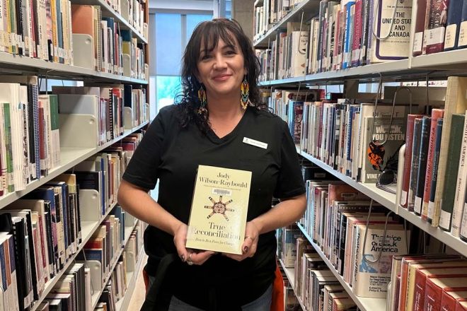 Sarah Lechthaler holds a copy of the book Truth and Reconciliation