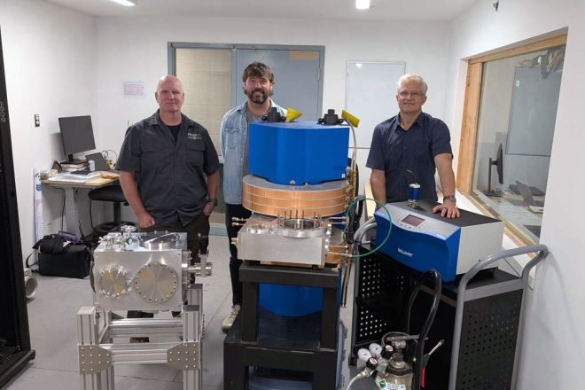 Three people stand with equipment