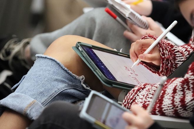 Students sit in class and take notes