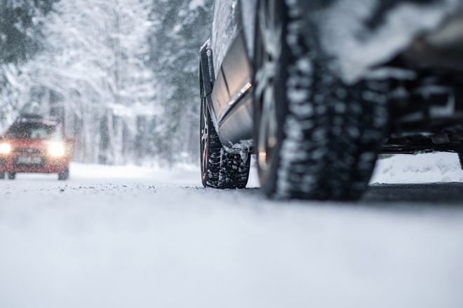A close-up of a car driving on a snowy road