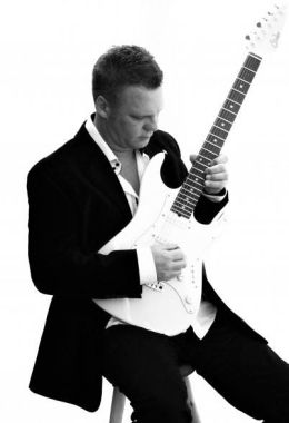 An image of Darren Mahe playing guitar
